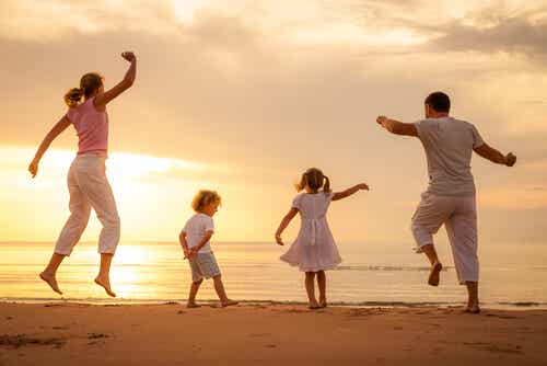Familie på stranden nyder sommerplaner med børn