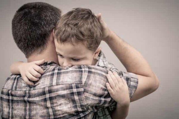 A man and a child hugging.