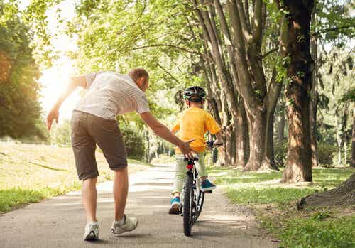 A man teaching a child to bike.