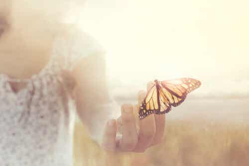 Kvinde med sommerfugl på hånden