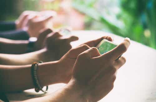 En bild av händer som håller smartphones.