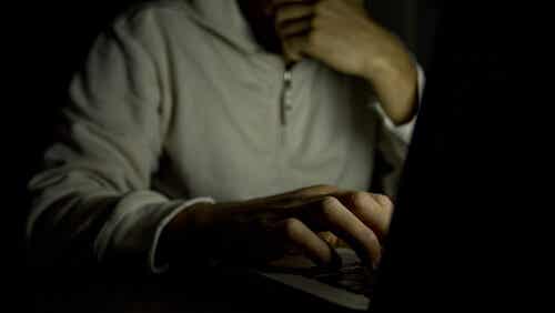 A person looking at a computer screen in the dark, supposedly with and addiction to pornography.