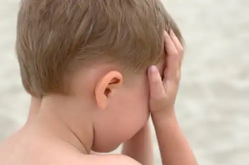 A child with his face in his hands showing childhood anxiety.