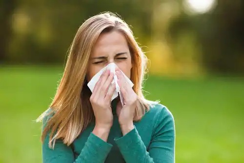 A woman blowing her nose.