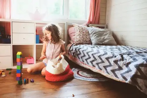 Kind ruimt speelgoed op