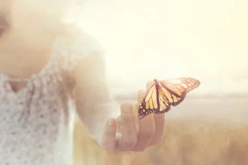 A woman holding a butterfly.