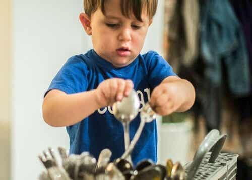 A child loading a dishwasher.