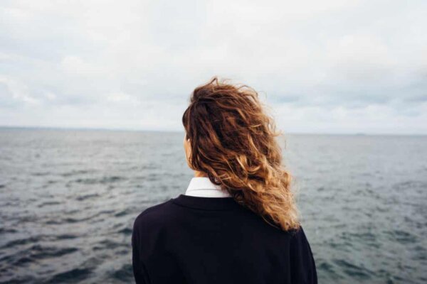 Een vrouw die naar zee staart