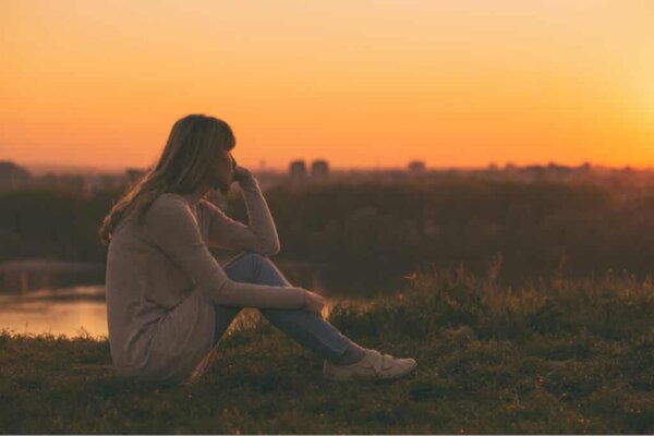 Een vrouw die naar de zonsondergang kijkt
