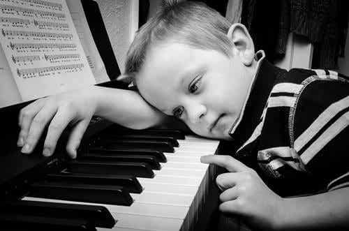 Trött pojke vid ett piano.