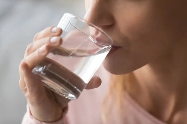 Een vrouw die een glas water drinkt