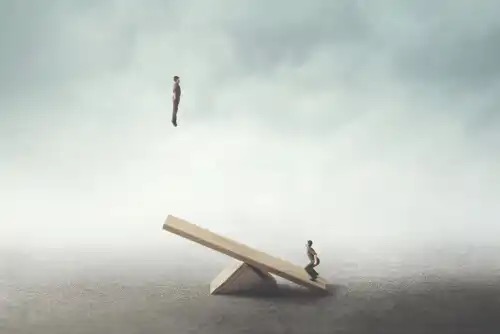Two men on a seesaw, demonstrating a joke.