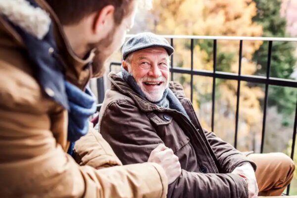 An elderly man laughing.
