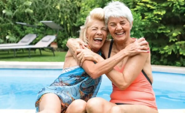 Two elderly ladies laughing together.