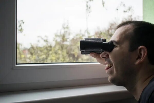 A man looking through binoculars.