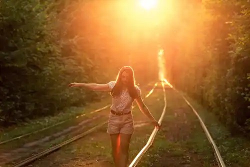 Vrouw balanceert op een treinspoor