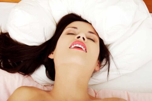 A woman smiling in bed.