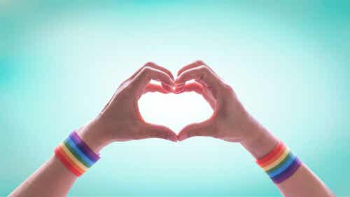 Iemand met regenboogbandjes vormt een hart