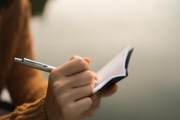 A person writing in a book.