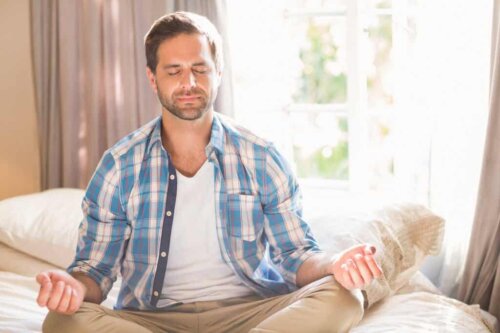 A man meditating in bed.