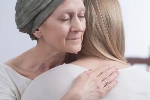 A cancer sufferer hugging another woman.