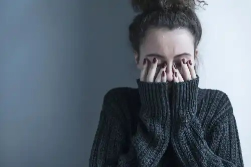A woman with her head in her hands.