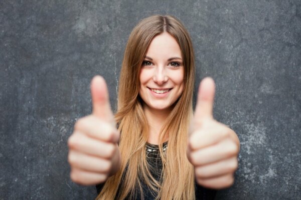 Kvinde har tommelfingrene oppe for at øge optimisme
